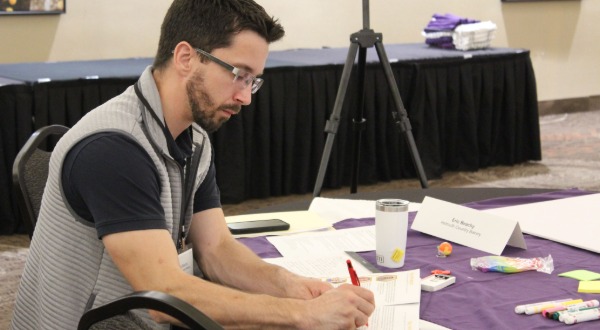 Eric Beachy sitting at table writing during Food Business Start-Up Summit