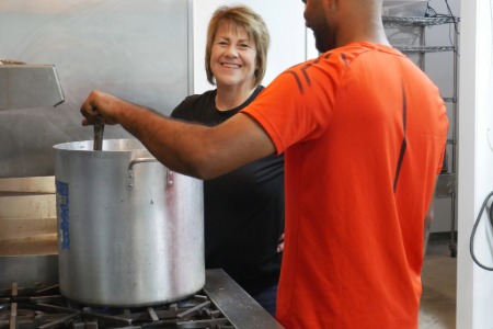 Two people next to large pot