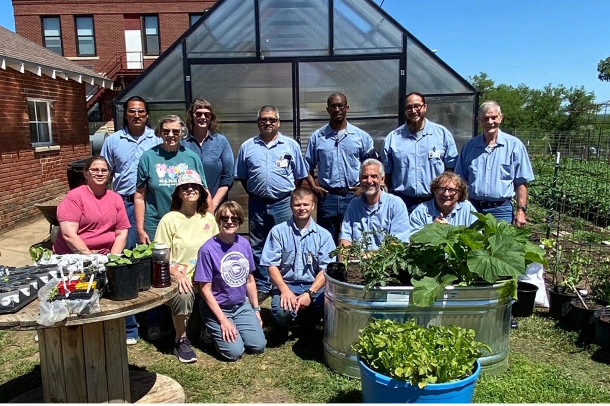 Gardening group posing in front of green house at Winfield Correctional Facility