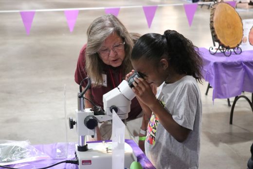 Sedgwick County EMG assists youth looking through a microscope