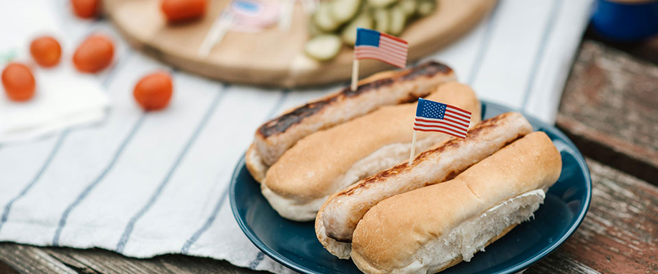 Plate of hot dogs with American flag on toothpick