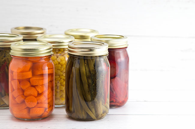 Five glass jars with various foods safely sealed inside