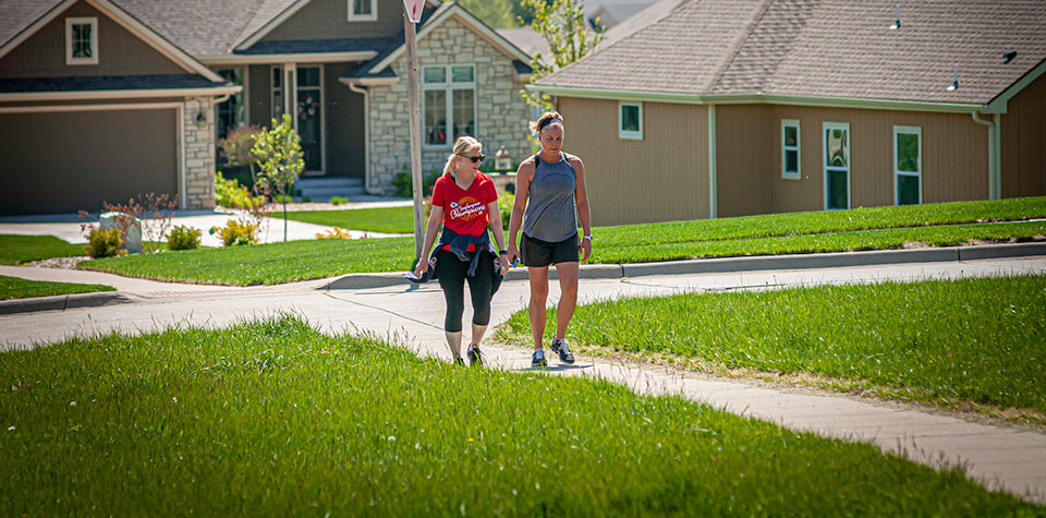 Two women walking together in a suburban neighborhood Two women walking together in a suburban neighborhood