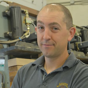 Smiling man with grey shirt looking into camera