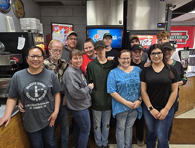 Group of people standing in front of drink machines in a convenience store
