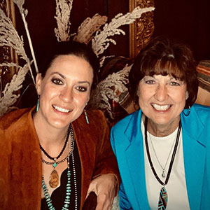 Two women smiling and looking directly into the camera