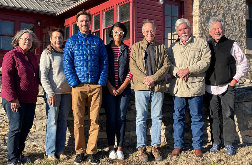 Group of seven people standing in front of red building Group of seven people standing in front of red building