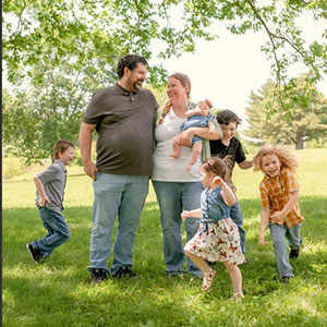 Man and woman with five children standing in a green field