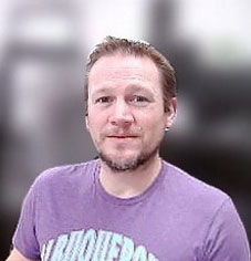 Man smiling at camera wearing purple shirt Man smiling at camera wearing purple shirt