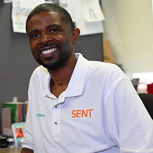 portrait of african american man wearing a white shirt and smiling at the camera