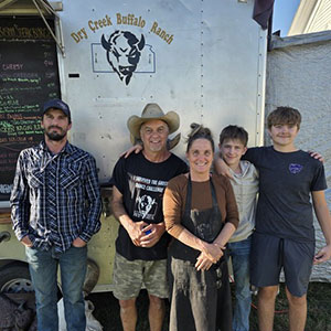 Five people standing along wall, staff of Dry Creek Buffalo Ranch