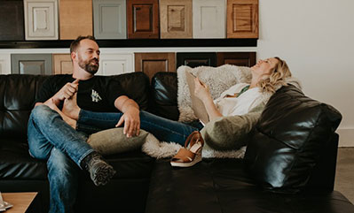 Man and woman sitting on a black couch in a design showroom