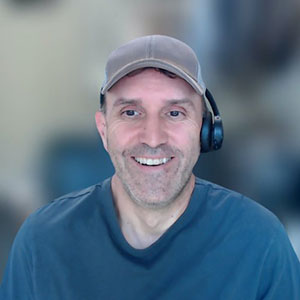 Smiling man wearing ball cap and blue shirt