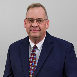 Portrait of man wearing a blue suit and glasses, short haircut