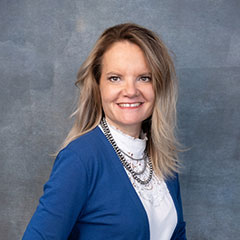 Portrait of woman with blue suit and smiling at the camera