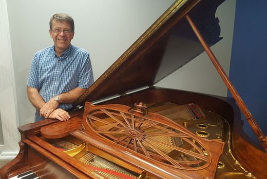 Man standing at art case piano