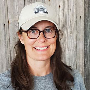 Woman wearing white hat and smiling at camera