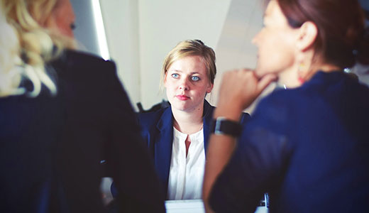 Three women sitting at table having a discussion