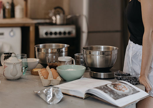 Counter with recipe book and various bowls and utensils Counter with recipe book and various bowls and utensils